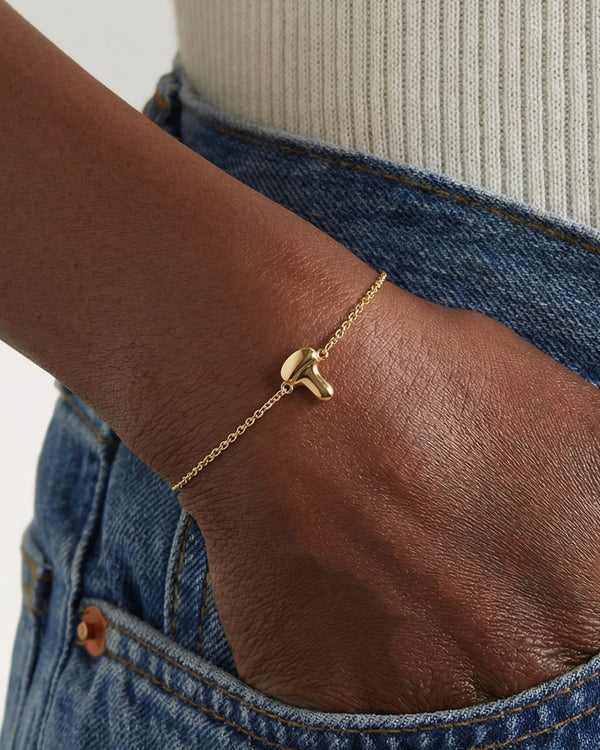 Gold bracelet featuring an ultrasound probe pendant charm modeled on a wrist